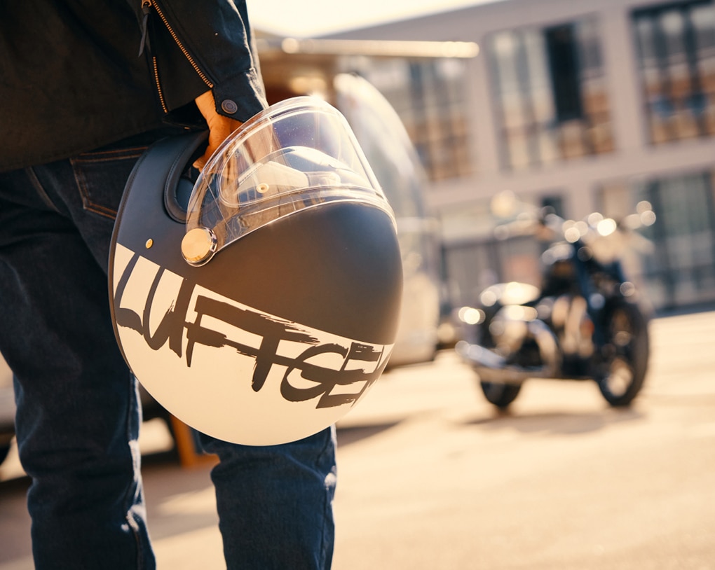 Person som håller i en motorcykelhjälm